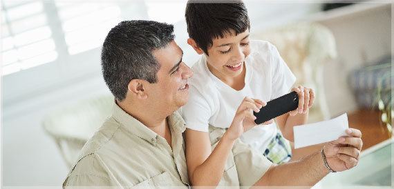 Father and son depositing check with mobile phone