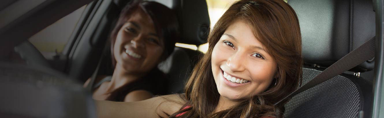 Two young girls in a car smiling